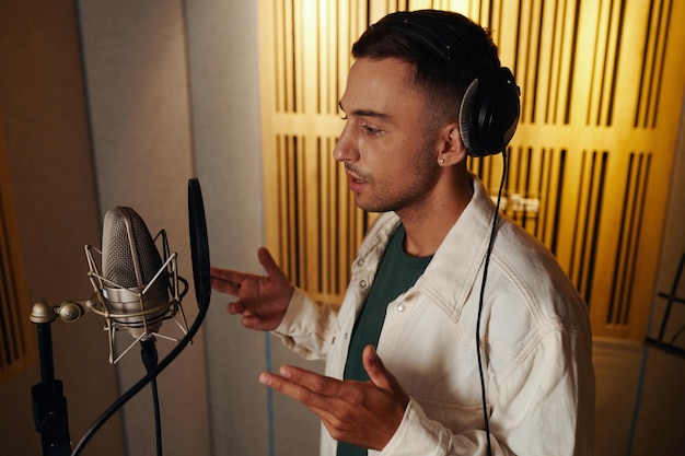 Student practicing voice exercises with guidance in modern music studio environment
