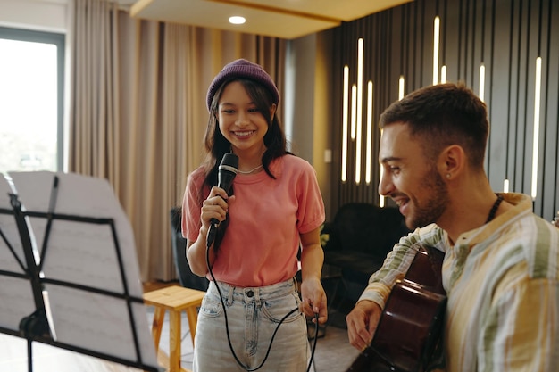 Professional singing lessons instructor demonstrating vocal techniques with microphone
